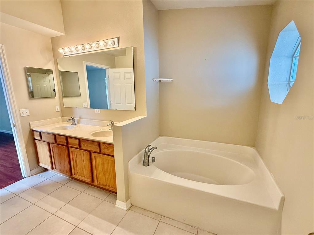1346 Rolling River Road DeLand, FL 32720 - Photo 16 of 31 a bathroom with a tub sink and mirror