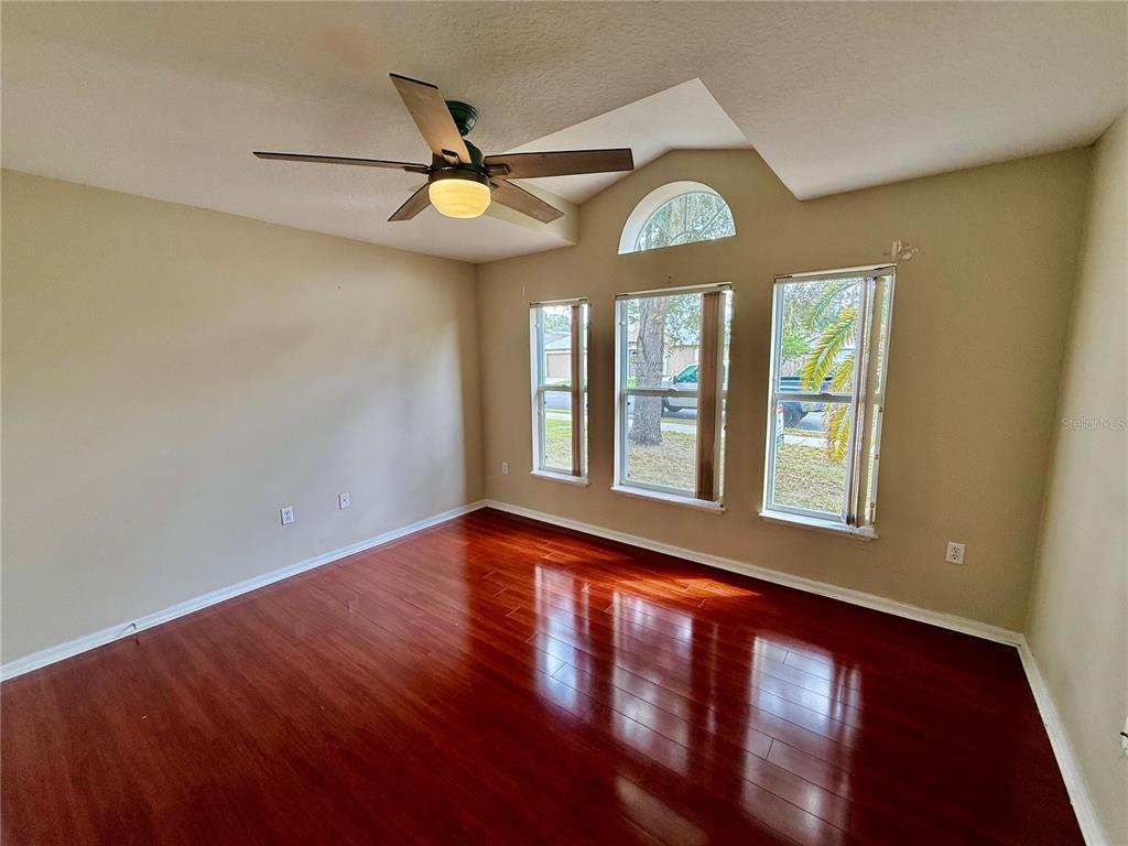 1346 Rolling River Road DeLand, FL 32720 - Photo 23 of 31 an empty room with wooden floor fan and windows