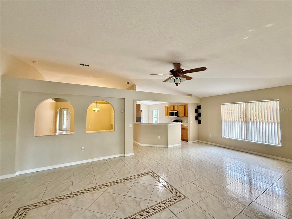 1346 Rolling River Road DeLand, FL 32720 - Photo 7 of 31 a view of a livingroom with wooden floor and a ceiling fan