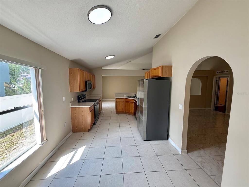 1346 Rolling River Road DeLand, FL 32720 - Photo 8 of 31 a view of kitchen with refrigerator and window