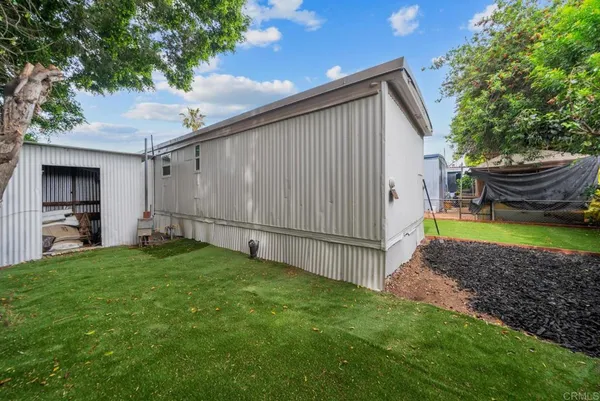 a view of a backyard with potted plants and a large tree