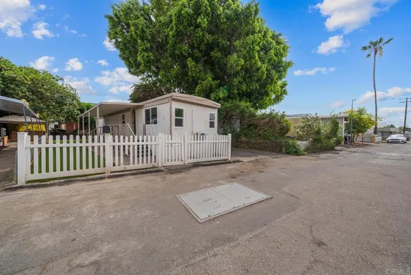 a view of a house with a yard and fence