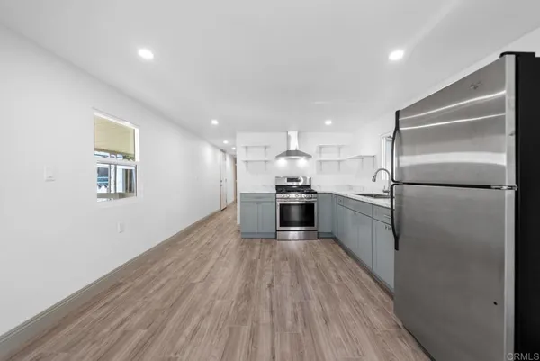 a kitchen with stainless steel appliances granite countertop a refrigerator a sink a stove and oven