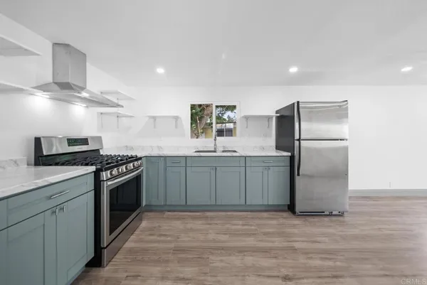 a kitchen with stainless steel appliances granite countertop a stove a sink and a refrigerator