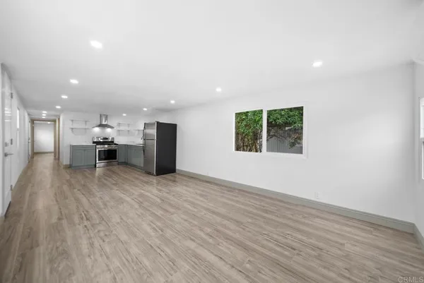 an empty room with a wooden floor and windows