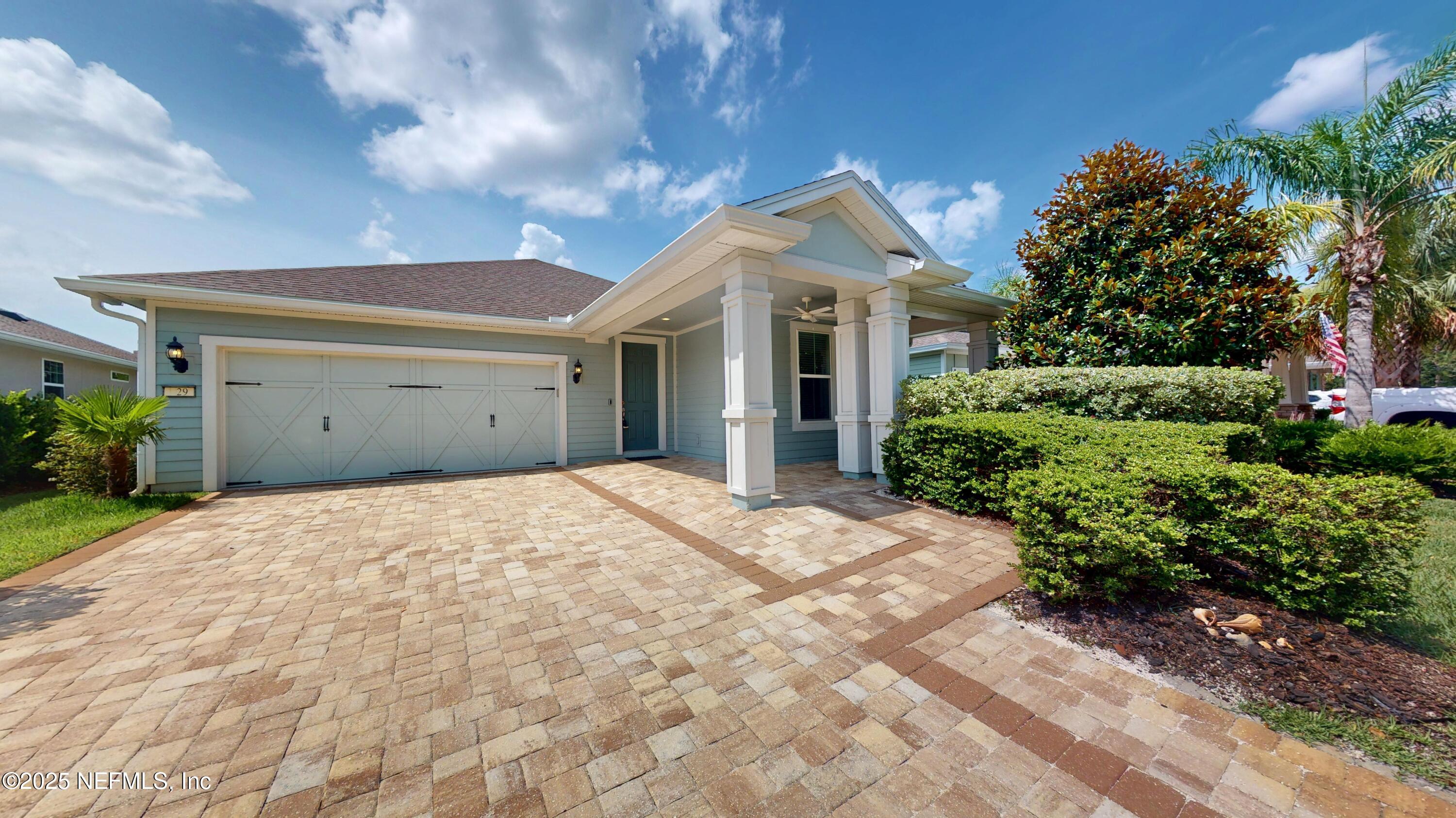 a front view of a house with a garden and plants