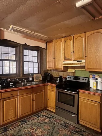 a kitchen with stainless steel appliances a stove a sink a stove and white cabinets