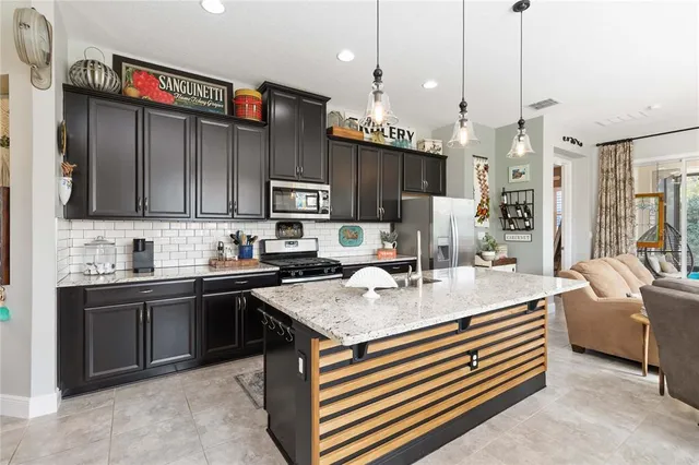 a kitchen with stainless steel appliances granite countertop a sink refrigerator and cabinets