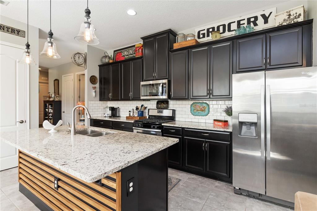 2463 Datura Loop St. Cloud, FL 34772 - Photo 15 of 57 a kitchen with stainless steel appliances granite countertop a sink refrigerator and cabinets
