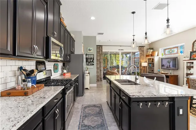 a kitchen with stainless steel appliances granite countertop a sink stove and refrigerator