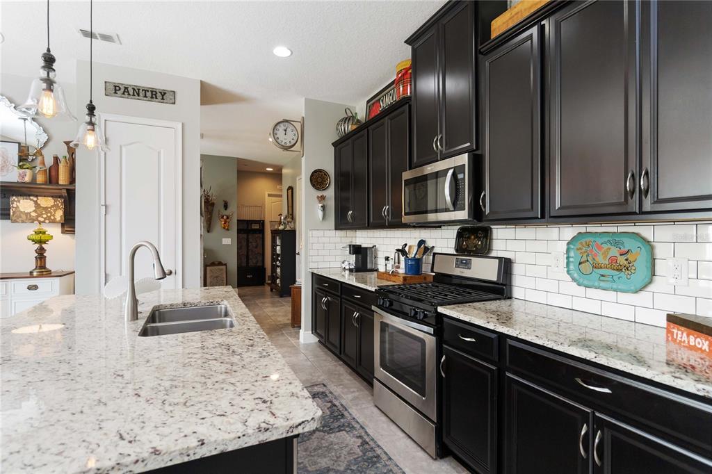 2463 Datura Loop St. Cloud, FL 34772 - Photo 18 of 57 a kitchen with stainless steel appliances granite countertop a sink stove and refrigerator