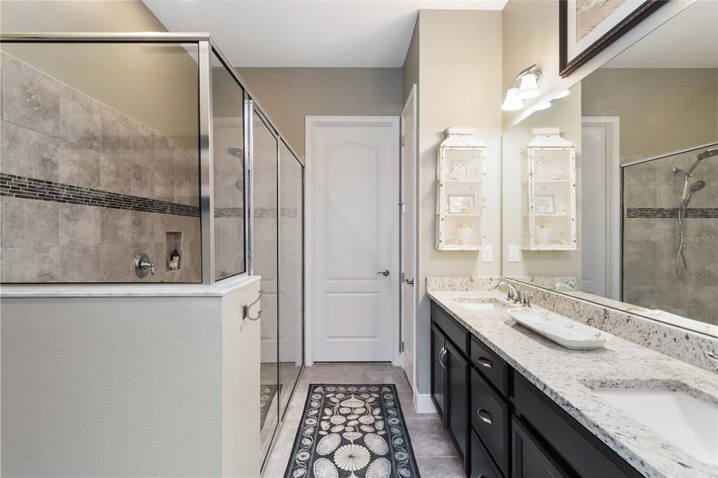 2463 Datura Loop St. Cloud, FL 34772 - Photo 22 of 57 a bathroom with a double vanity sink and mirror with shower