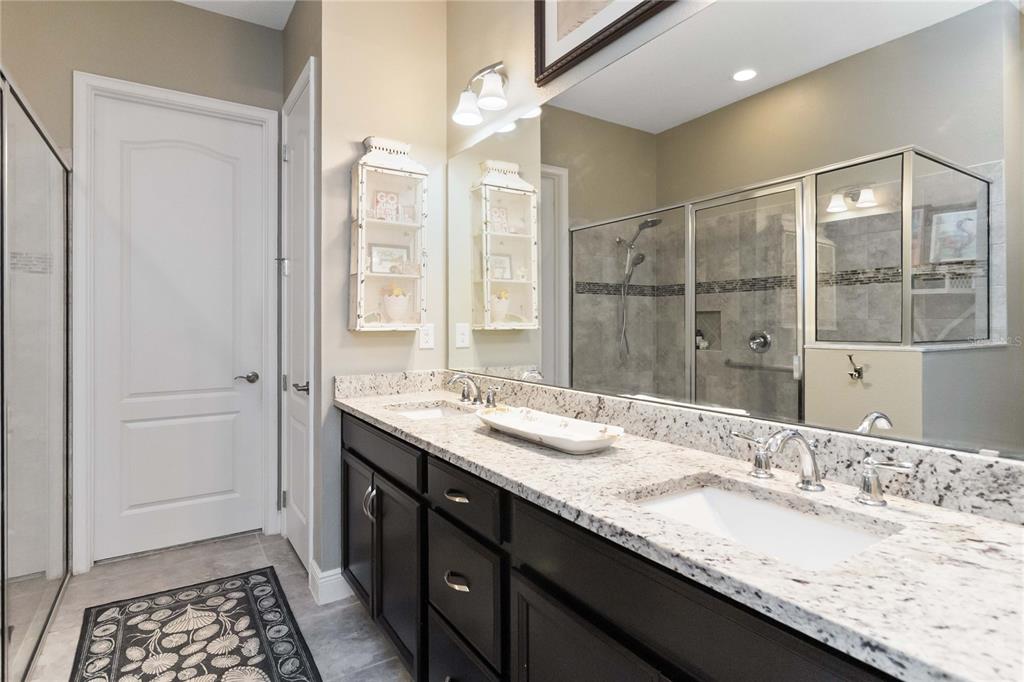 2463 Datura Loop St. Cloud, FL 34772 - Photo 23 of 57 a bathroom with a granite countertop sink a mirror and a shower