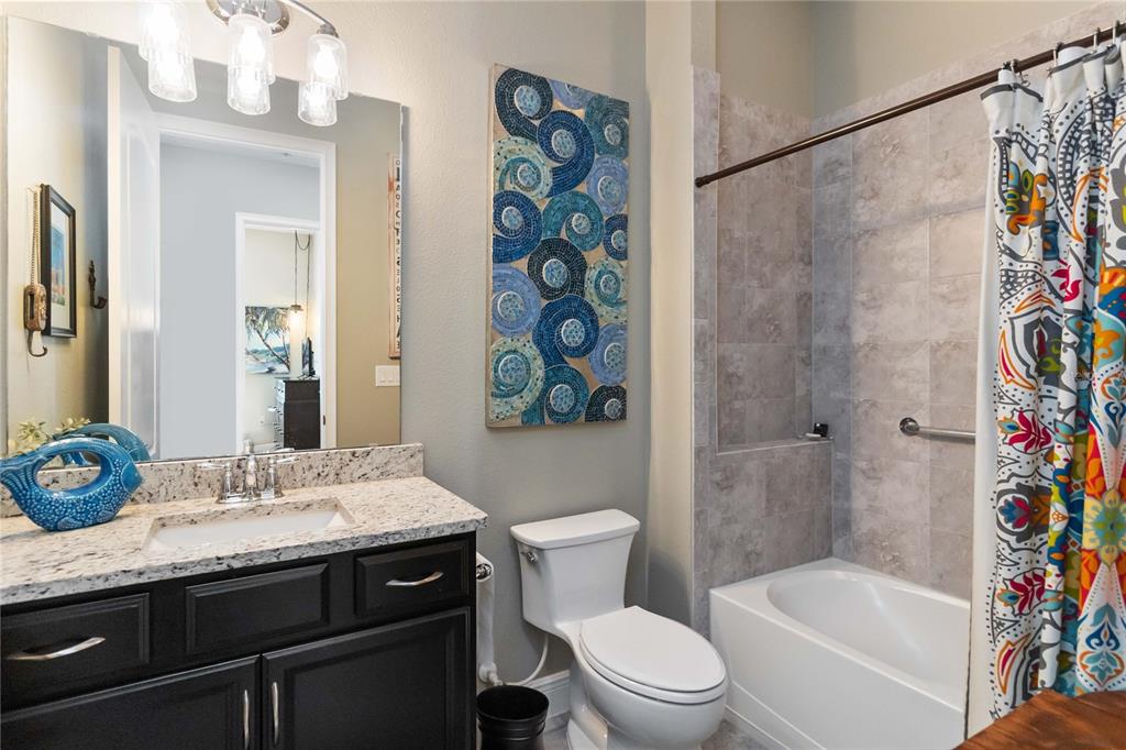 2463 Datura Loop St. Cloud, FL 34772 - Photo 34 of 57 a bathroom with a granite countertop sink a toilet a shower curtain and a bath tub