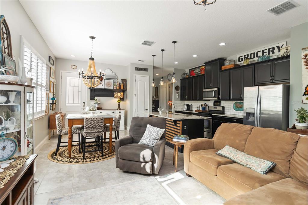2463 Datura Loop St. Cloud, FL 34772 - Photo 7 of 57 a living room with furniture a kitchen view and a chandelier