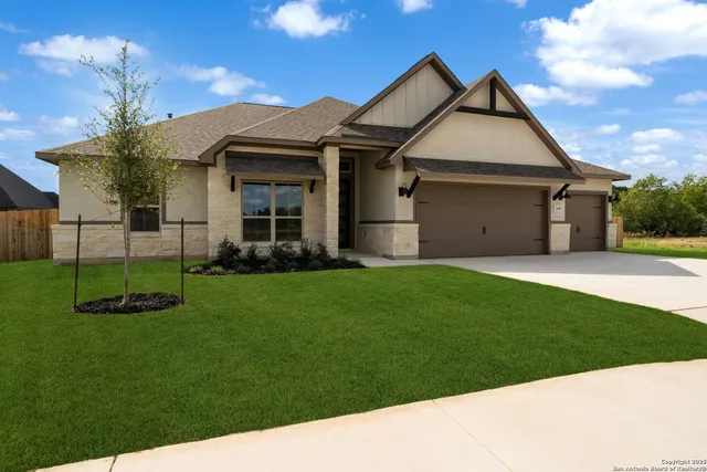 a front view of a house with a garden and yard