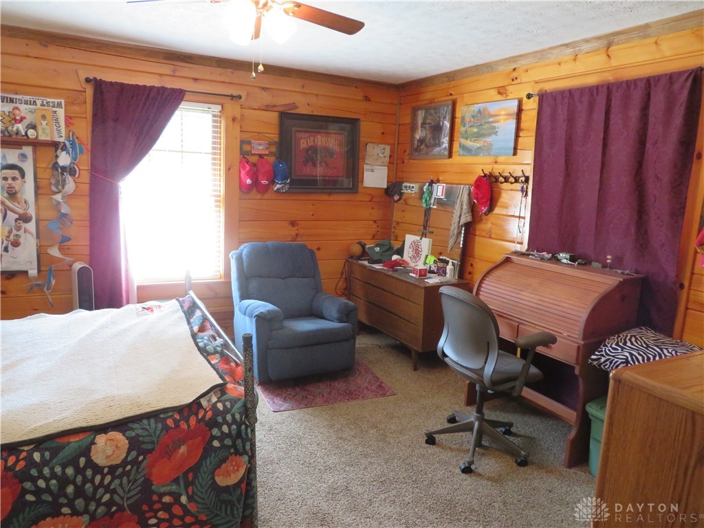 748 Inlow Avenue Peebles, OH 45660 - Photo 20 of 61 This cozy space features rustic wooden walls and soft carpet, creating a warm and inviting atmosphere.