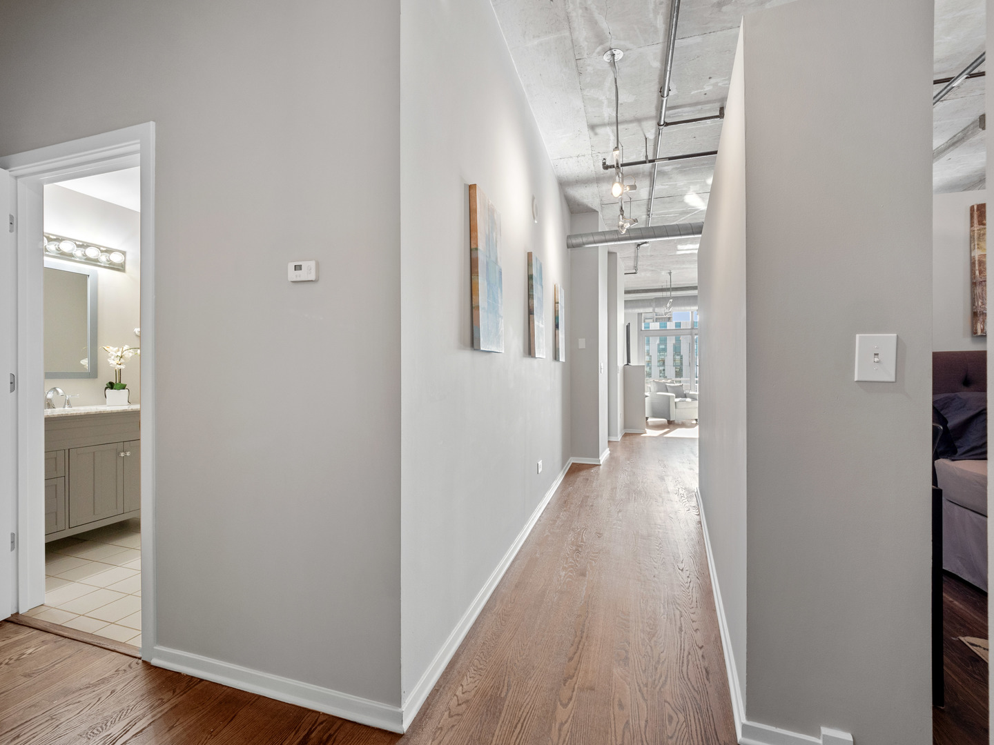 933 West Van Buren Street, Unit 708 Chicago, IL 60607 - Photo 15 of 23 a view of a hallway with wooden floor and a kitchen