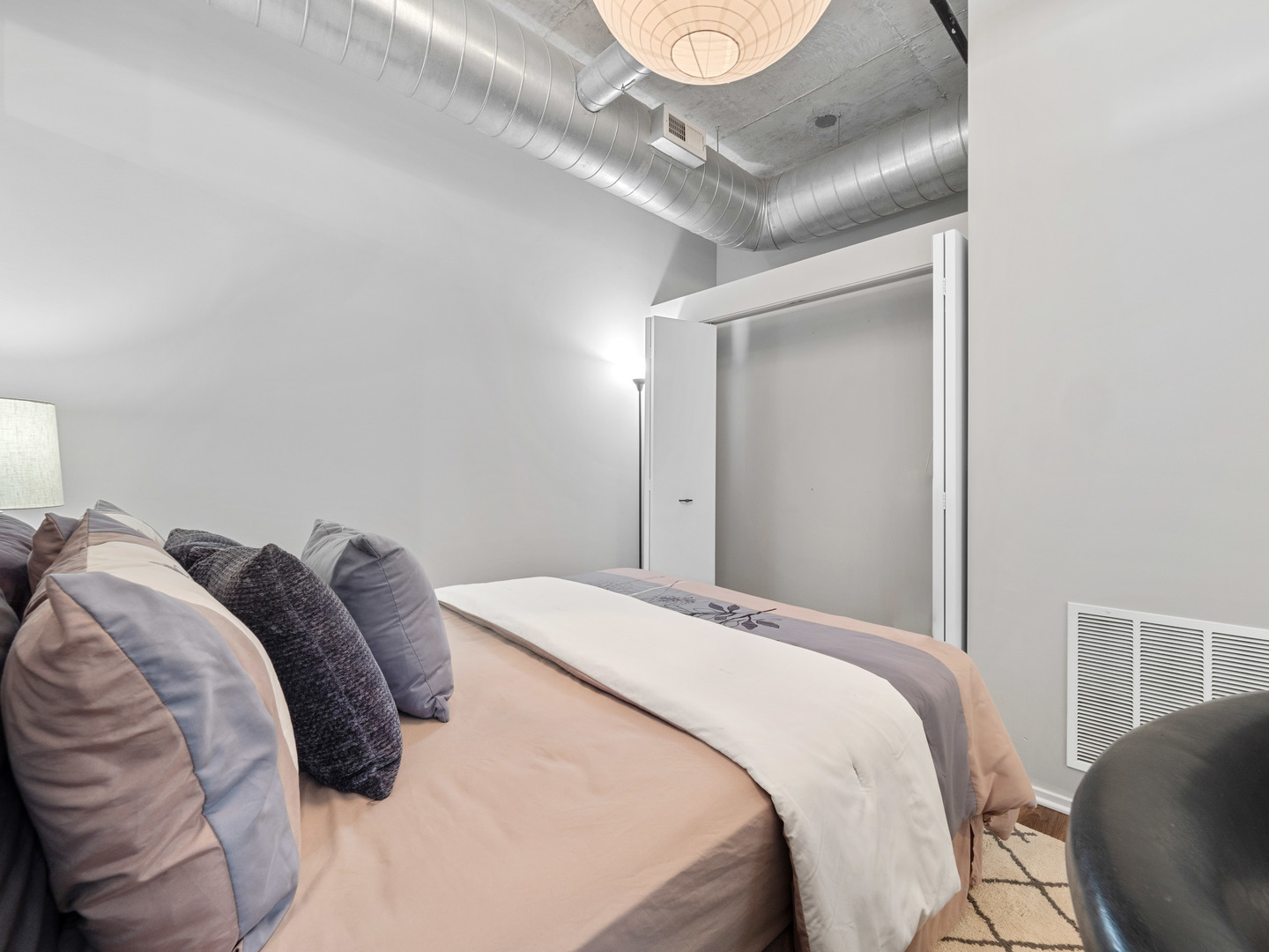 933 West Van Buren Street, Unit 708 Chicago, IL 60607 - Photo 17 of 23 a bedroom with a bed and a chandelier