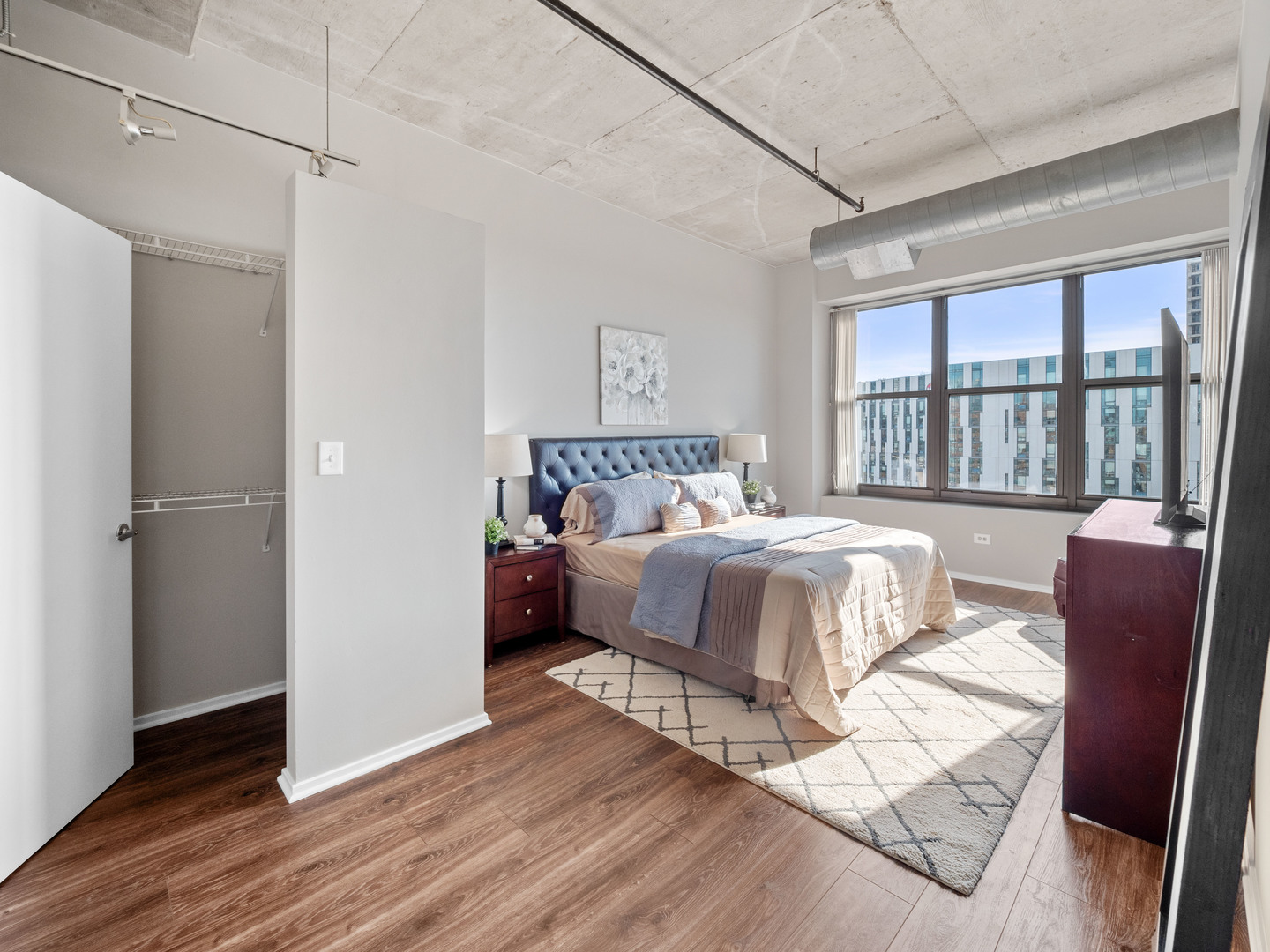 933 West Van Buren Street, Unit 708 Chicago, IL 60607 - Photo 9 of 23 a bedroom with a bed mirror and a window