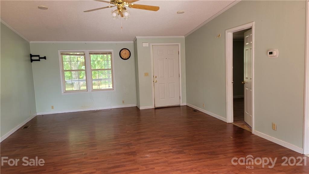 1108 Goldmine Road Chester, SC 29706 - Photo 3 of 17 an empty room with wooden floor chandelier fan and windows