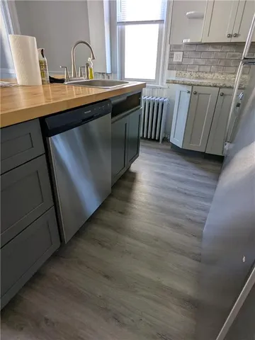 a kitchen with stainless steel appliances granite countertop a table chairs sink and cabinets