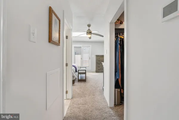 a view of a hallway with a livingroom and a bathroom