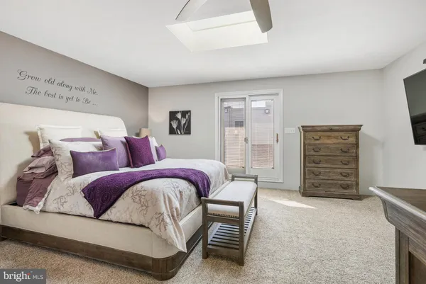 a bedroom with a bed a dresser and with chair