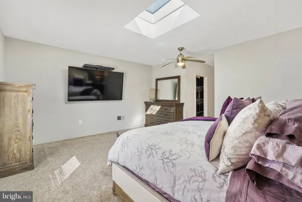 a spacious bedroom with a bed and a flat screen tv