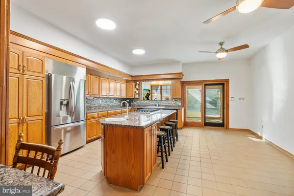 a kitchen with stainless steel appliances granite countertop a sink and a refrigerator