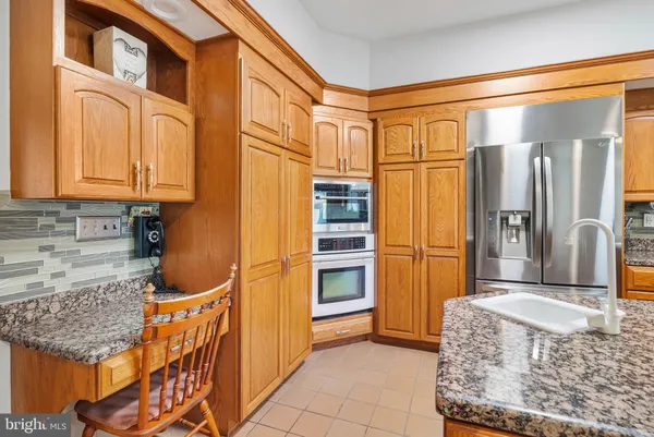 a kitchen with stainless steel appliances granite countertop a refrigerator and a sink