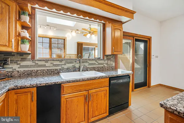 a kitchen with granite countertop cabinets a sink and a window
