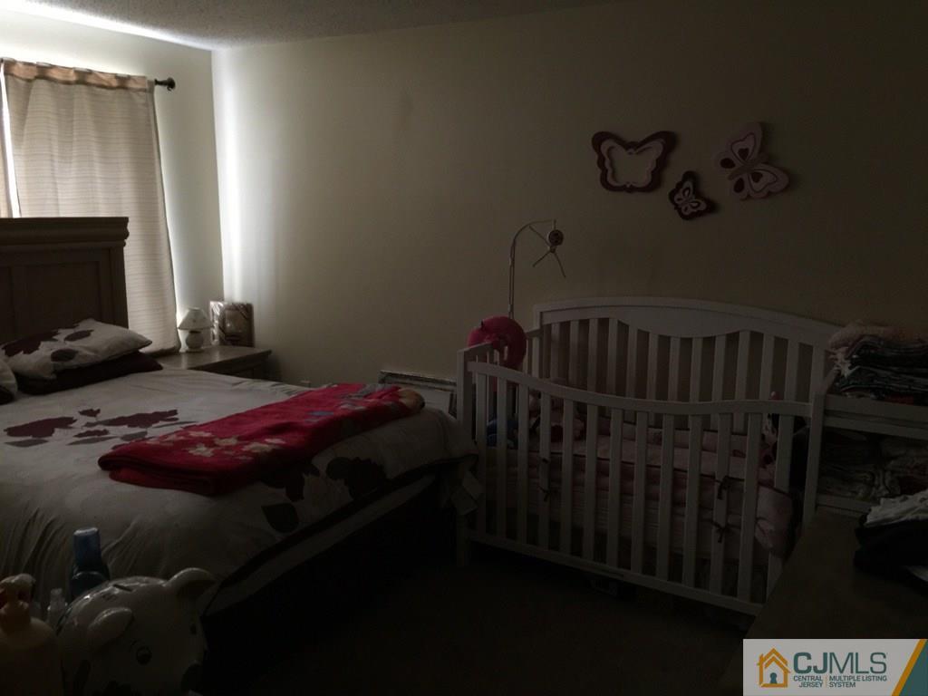531 Edpas Road, Unit 531 New Brunswick, NJ 08901 - Photo 6 of 9 a bedroom with a bed and a flat tv screen