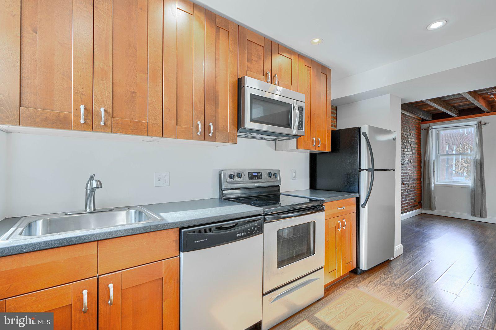 1026 Patapsco Street Baltimore, MD 21230 - Photo 7 of 24 a kitchen with stainless steel appliances granite countertop a refrigerator a stove a sink and a microwave