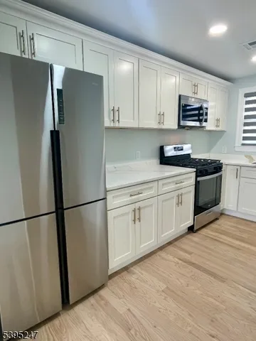 a kitchen with stainless steel appliances a refrigerator sink and microwave