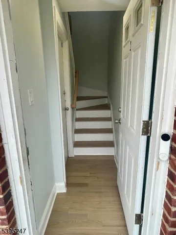 a view of a hallway with wooden floor and entryway