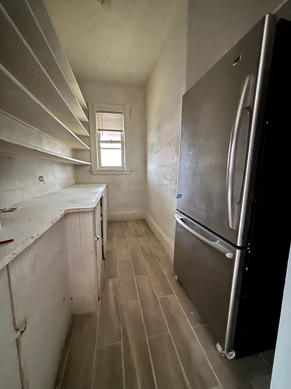 46 Evelyn Street, Unit 3 Boston, MA 02126 - Photo 3 of 13 a hallway with wooden floor electronic appliances and stairs