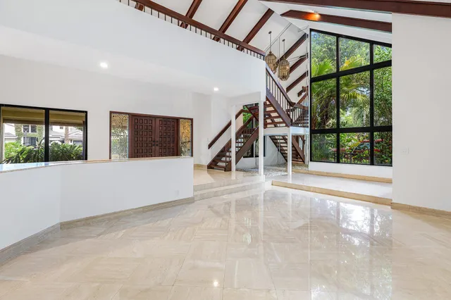 a front view of a house with potted plants and windows
