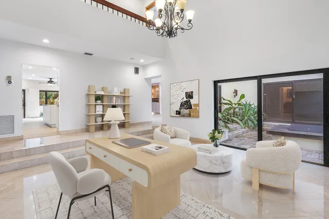 a view of a house with a big yard and palm trees