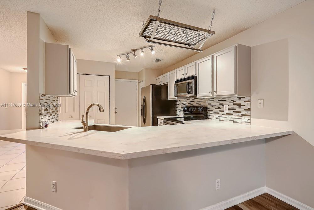 339 Timberwalk Trail Jupiter, FL 33458 - Photo 11 of 33 a kitchen with stainless steel appliances kitchen island granite countertop a sink and cabinets