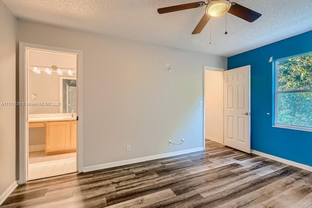 339 Timberwalk Trail Jupiter, FL 33458 - Photo 17 of 33 an empty room with wooden floor fan and windows