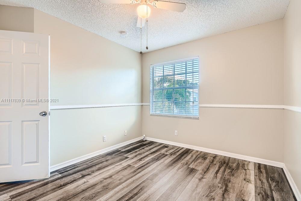 339 Timberwalk Trail Jupiter, FL 33458 - Photo 21 of 33 an empty room with wooden floor cabinet and windows