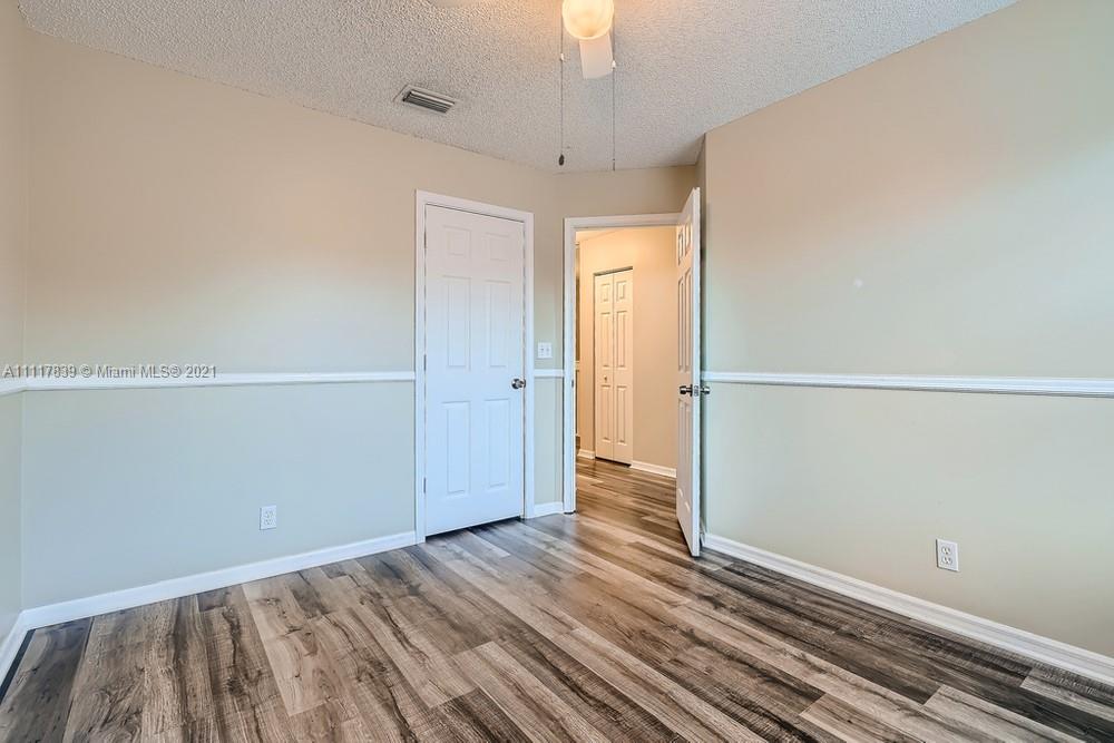 339 Timberwalk Trail Jupiter, FL 33458 - Photo 22 of 33 an empty room with wooden floor cabinet and windows