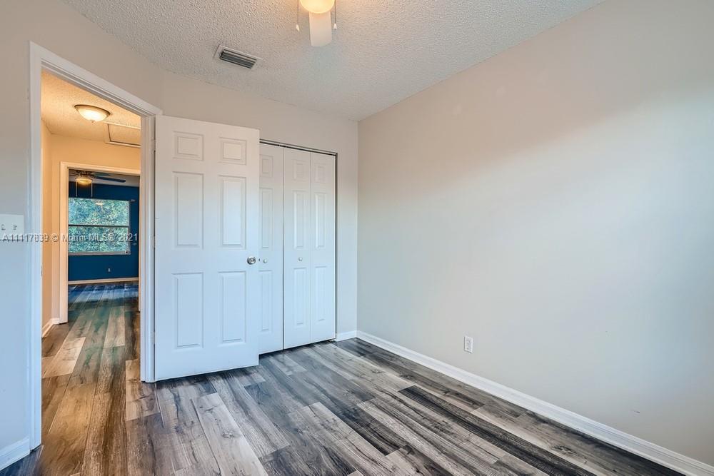 339 Timberwalk Trail Jupiter, FL 33458 - Photo 23 of 33 a view of an empty room with wooden floor and a window