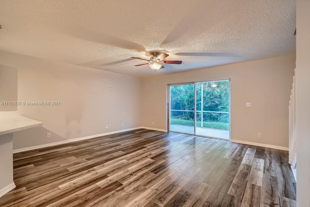 339 Timberwalk Trail Jupiter, FL 33458 - Photo 5 of 33 a view of an empty room with wooden floor and a window