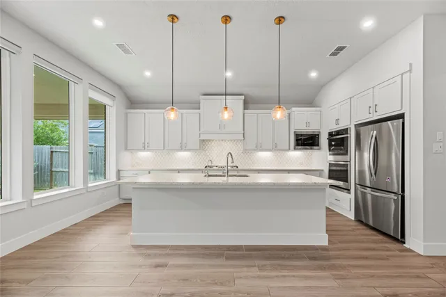 a view living room with stainless steel appliances granite countertop cabinets and a wooden floor