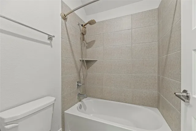 a white bath tub sitting next to a white toilet and a shower