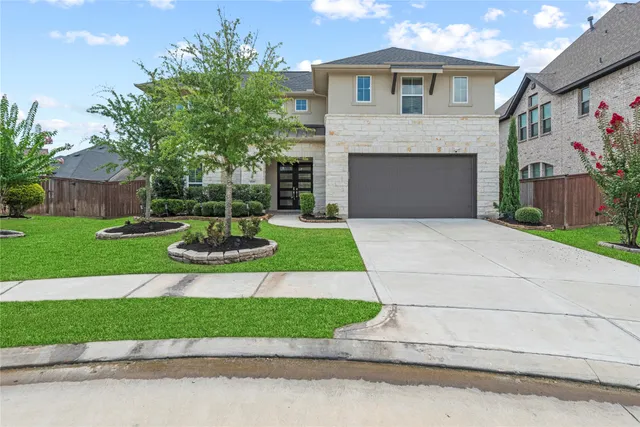 a front view of a house with a yard and garage