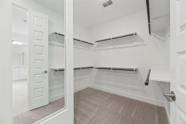 a view of walk in closet with empty racks