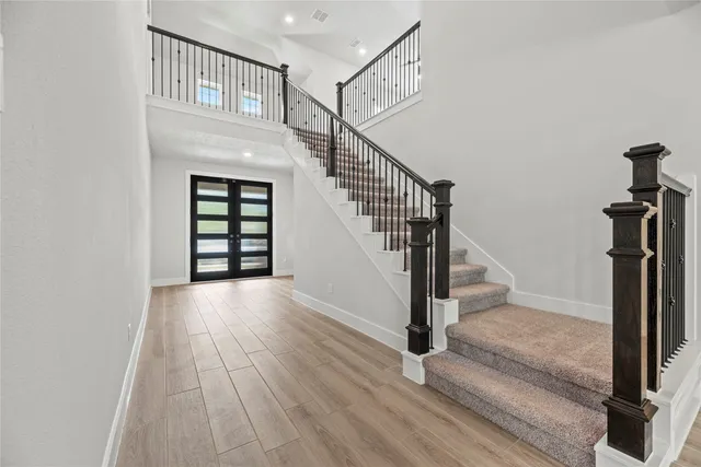 a view of a hallway with wooden floor and staircase